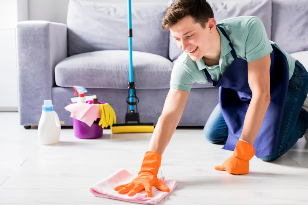 a young man cleaning floors smiling