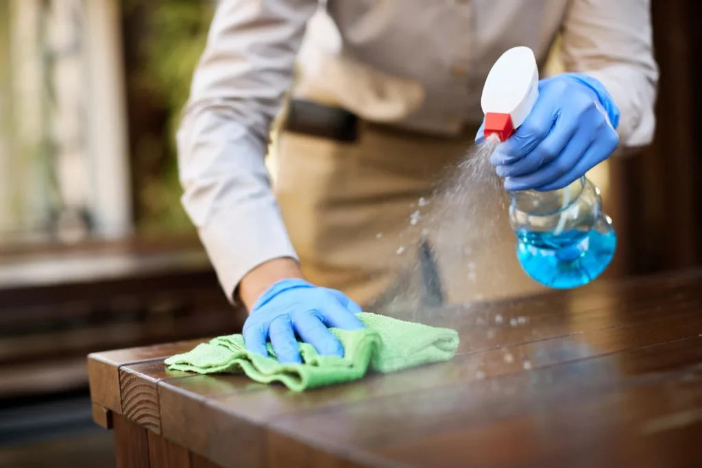 a man cleaning and spraying a table